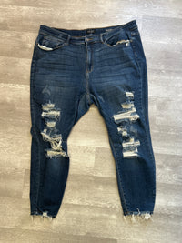 Distressed blue jeans on a wooden floor