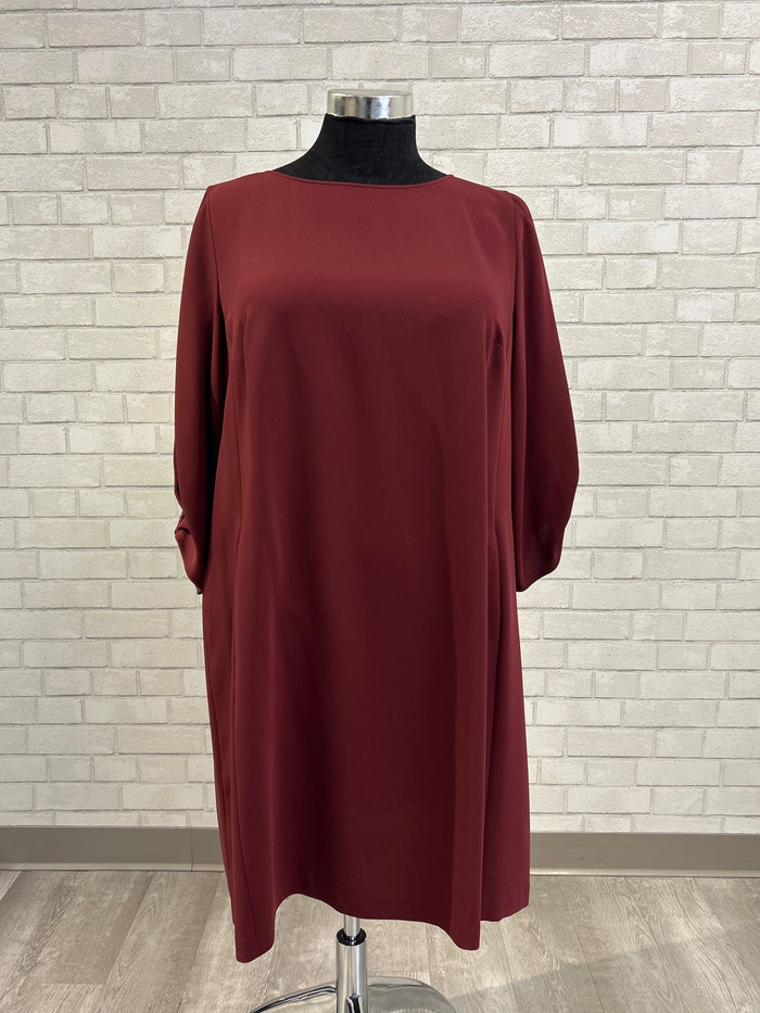 Red dress on a mannequin against a tiled wall background