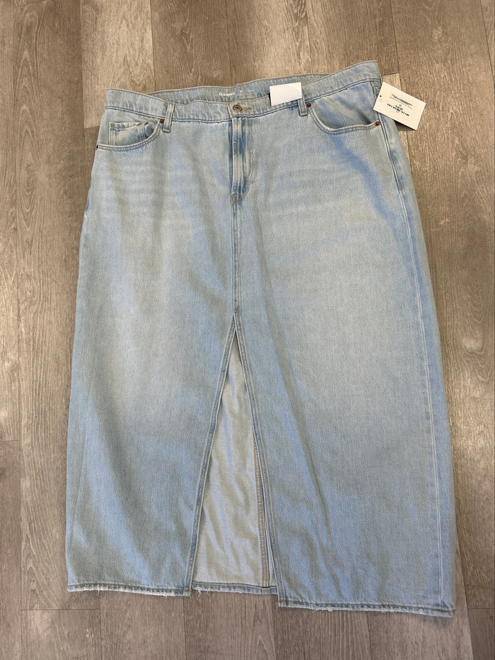 Light blue jeans on a wooden floor with a tag attached.