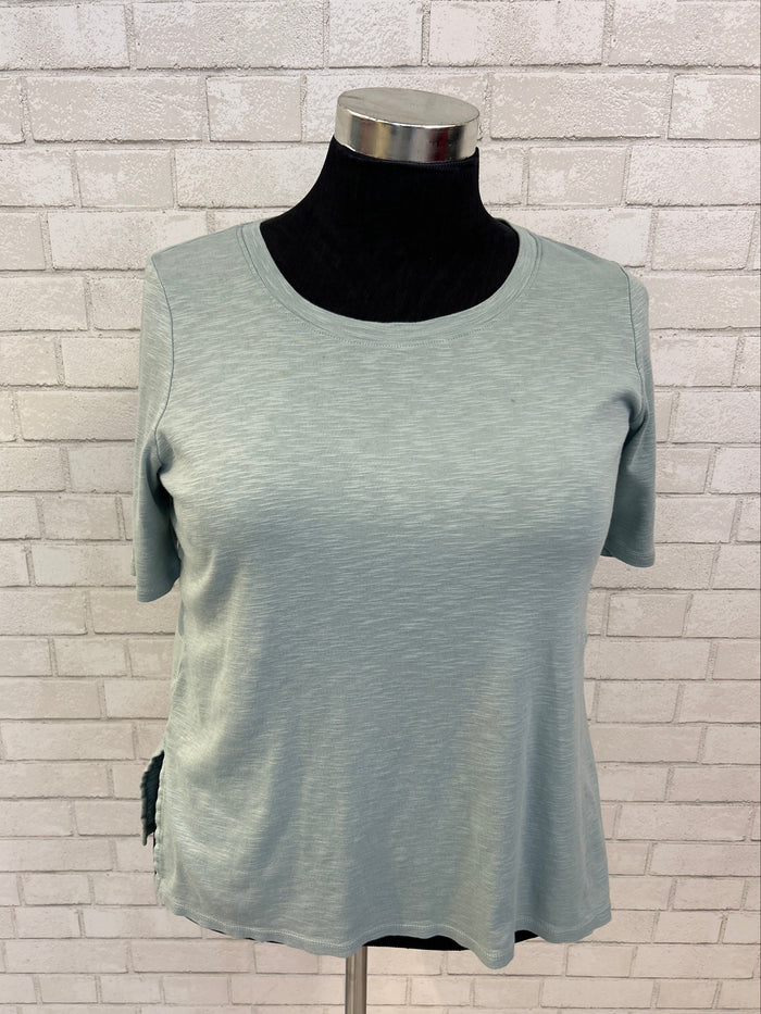 Light gray sleeveless top on a mannequin against a tiled wall background