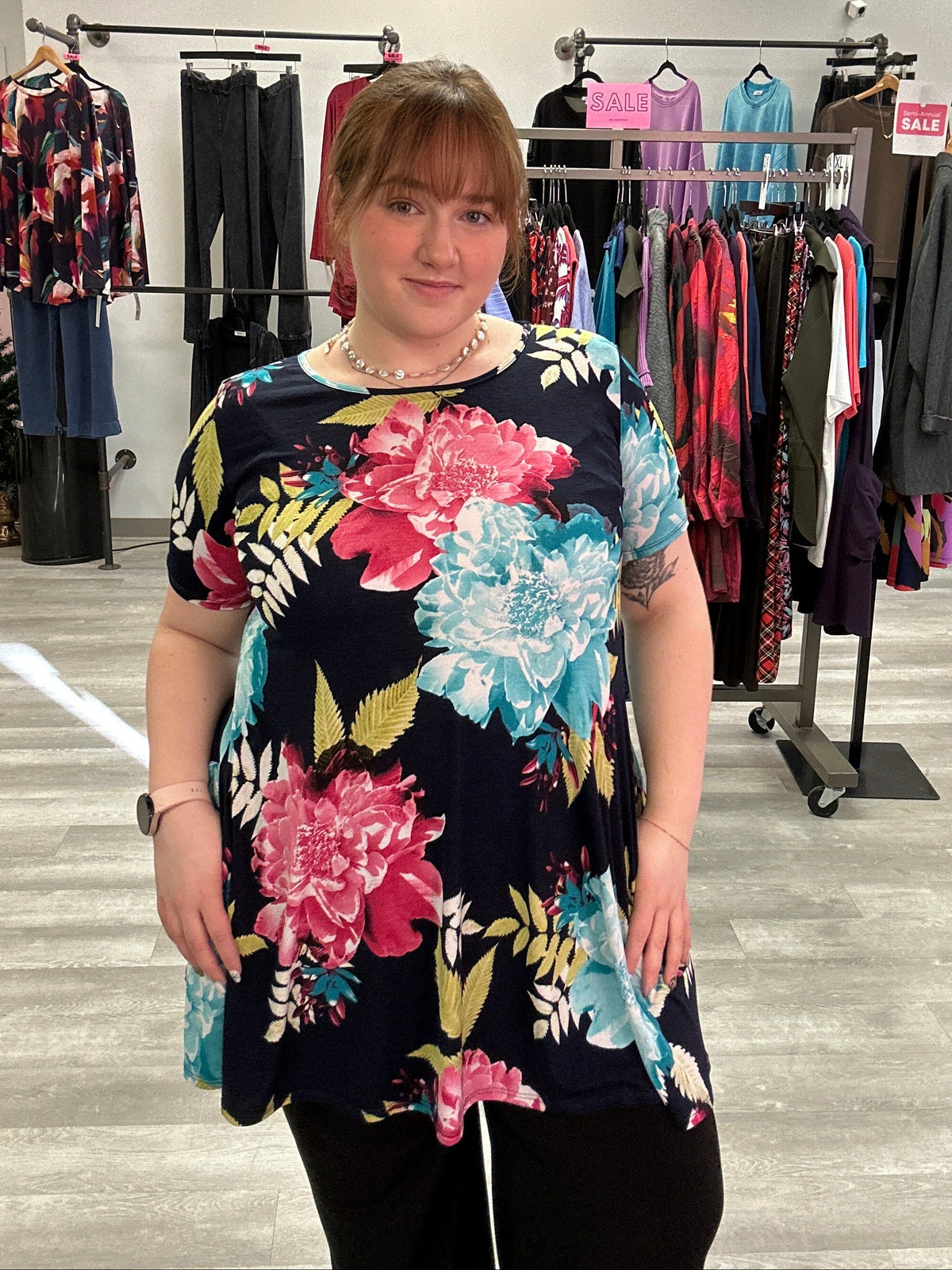 Person wearing a floral dress in a clothing store