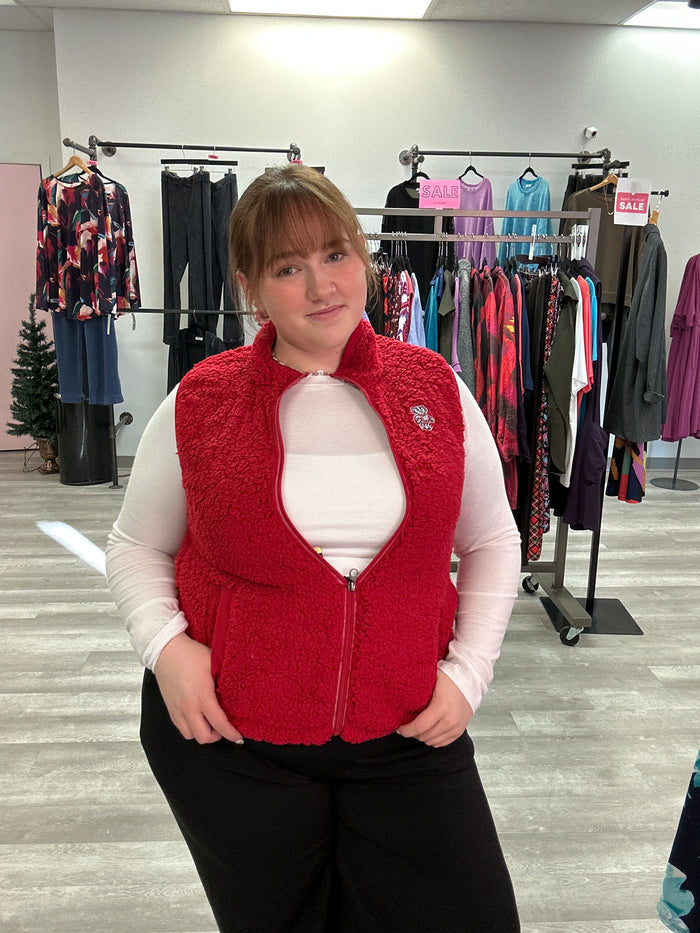 Person wearing a red vest in a clothing store