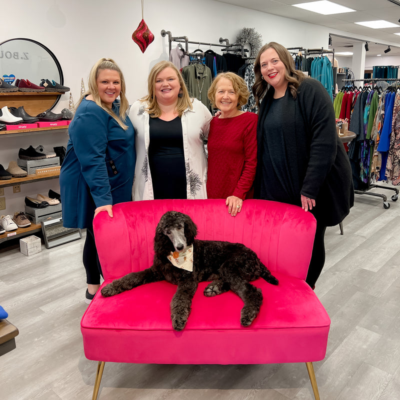 A photo of the Z Boutique team posing with the shop dog.
