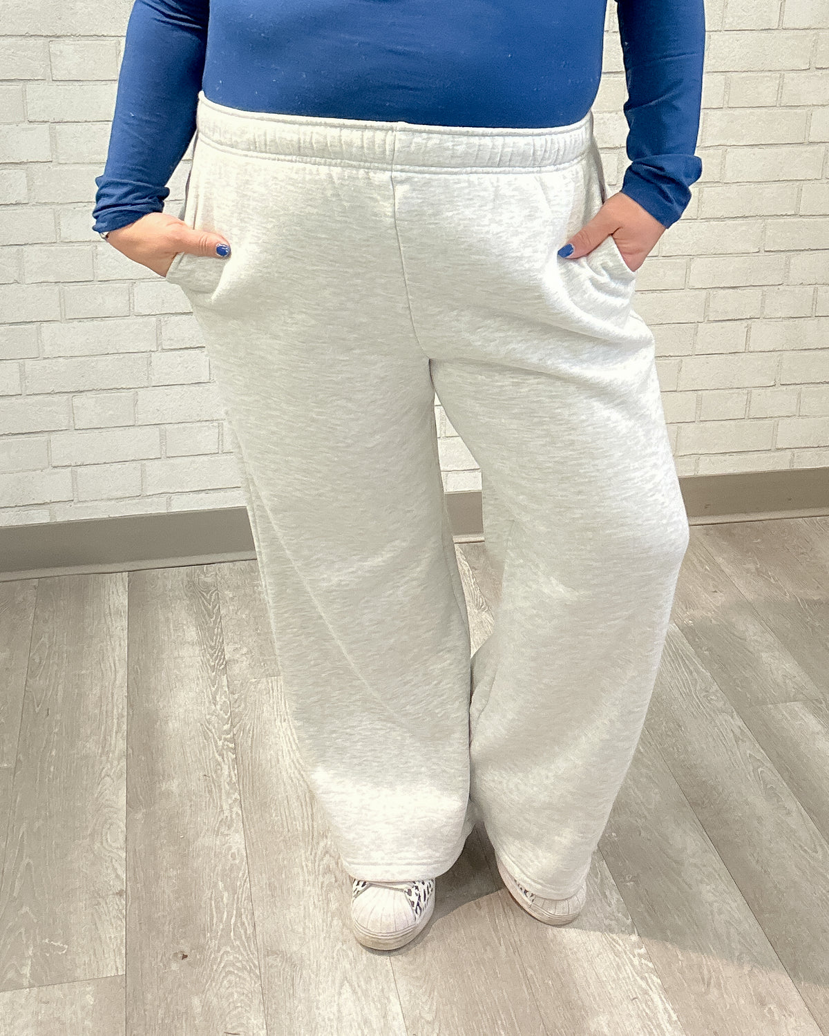 Person wearing gray sweatpants and a blue top in a bathroom setting