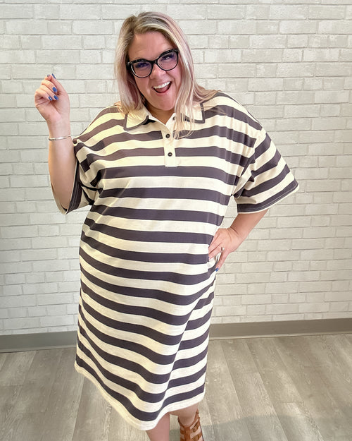 Woman wearing a striped dress with a white brick wall background