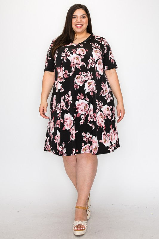 Plus Size Floral A-Line Dress. Black background with pink, white, yellow floral design throughout. V-neck, short sleeves, side pockets.